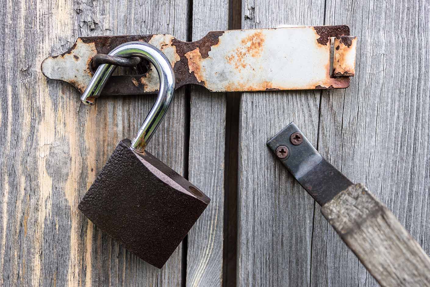 steel-and-reliable-padlock-hanging-on-the-wooden-d-2024-12-04-04-44-43-utc image of a steel padlock hanging on a wooden door
